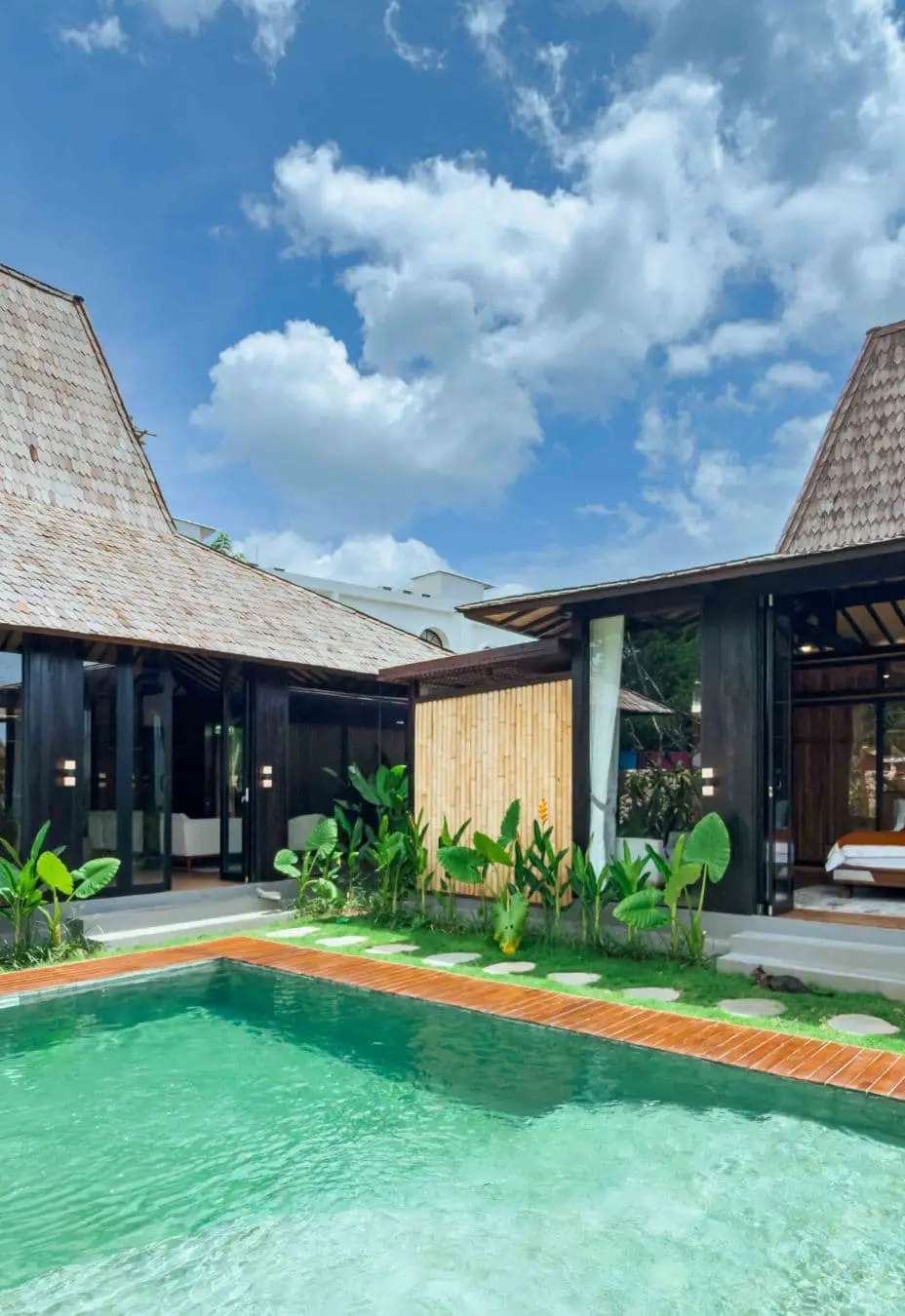 Master bedroom and second bedroom overlooking the pool in a contemporary Joglo-style villa in Bali